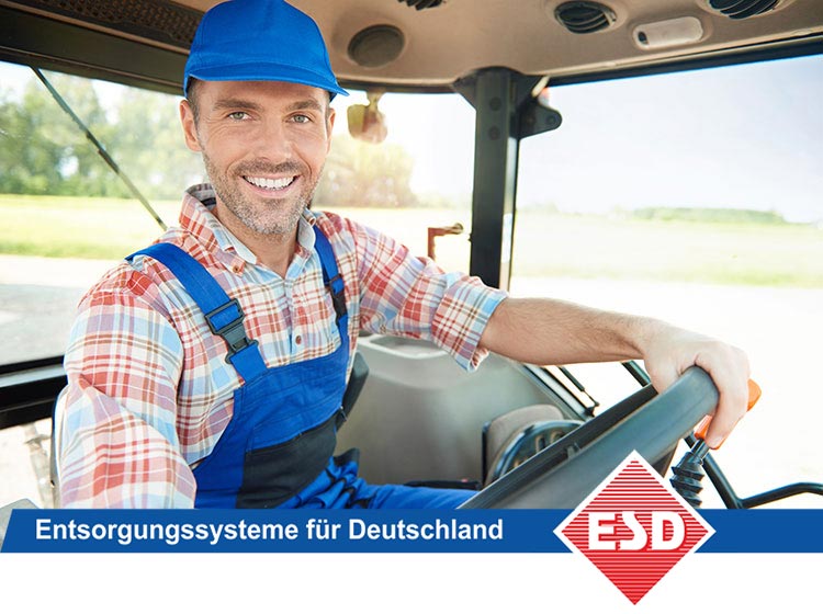 Lächelnder Arbeiter fährt Traktor auf dem Feld