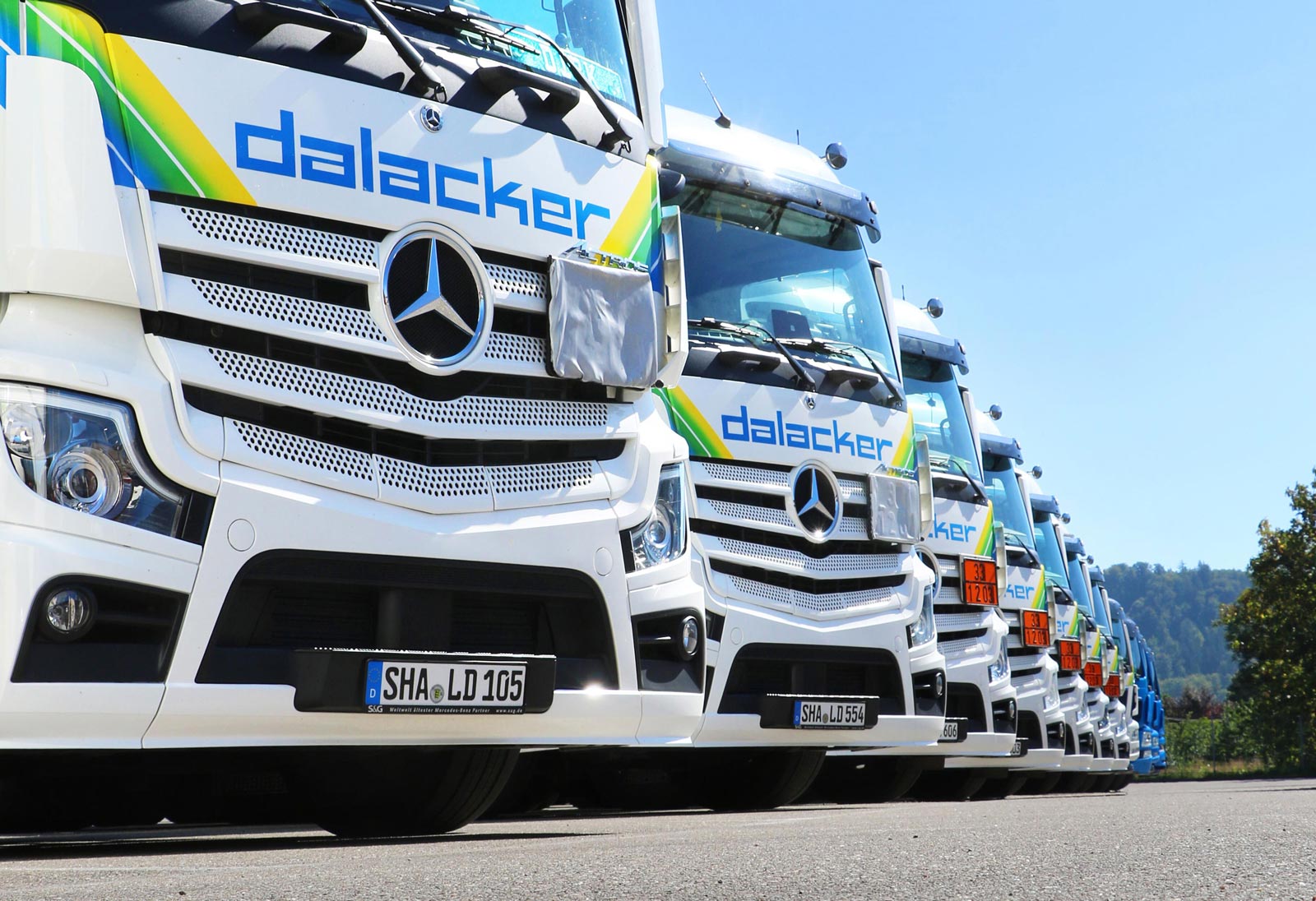 Reihe moderner Mercedes-Lkw auf Parkplatz